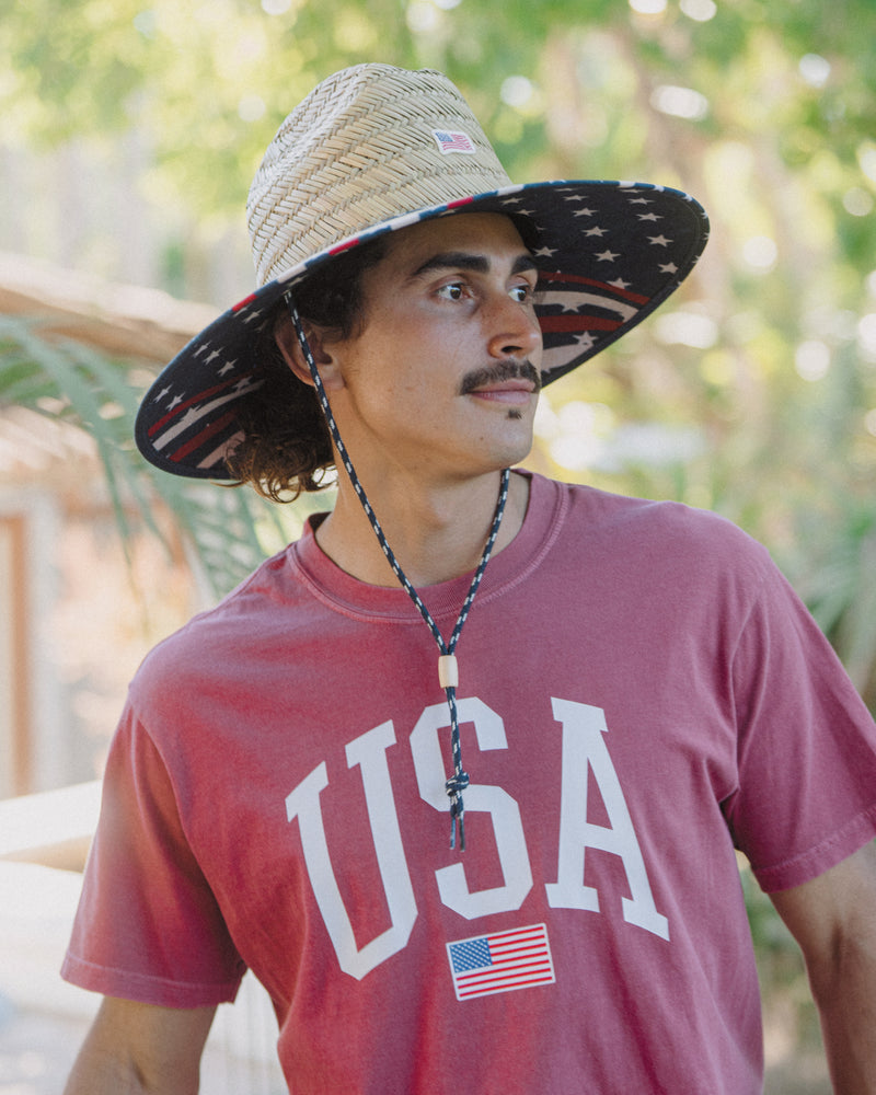 Hemlock male model wearing the UPF50+ Lifeguard Straw Hat Stars & Stripes print side profile